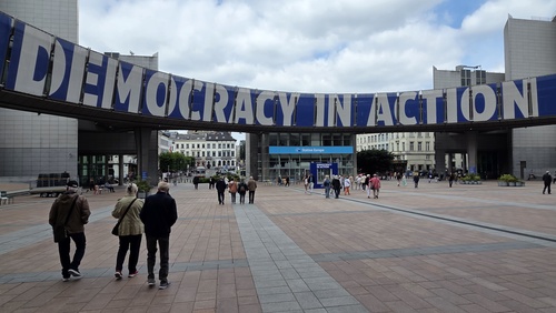 Platz im Europaviertel in Brüssel. Oberhalb ein Schriftzug "Democracy in action"