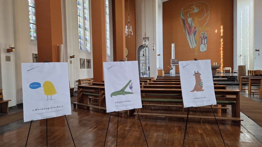 In der katholischen Kirche sind Plakate einer Ausstellung zu Demokratie zu sehen